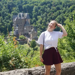 Woman posing in front of Eltz Castle in Germany